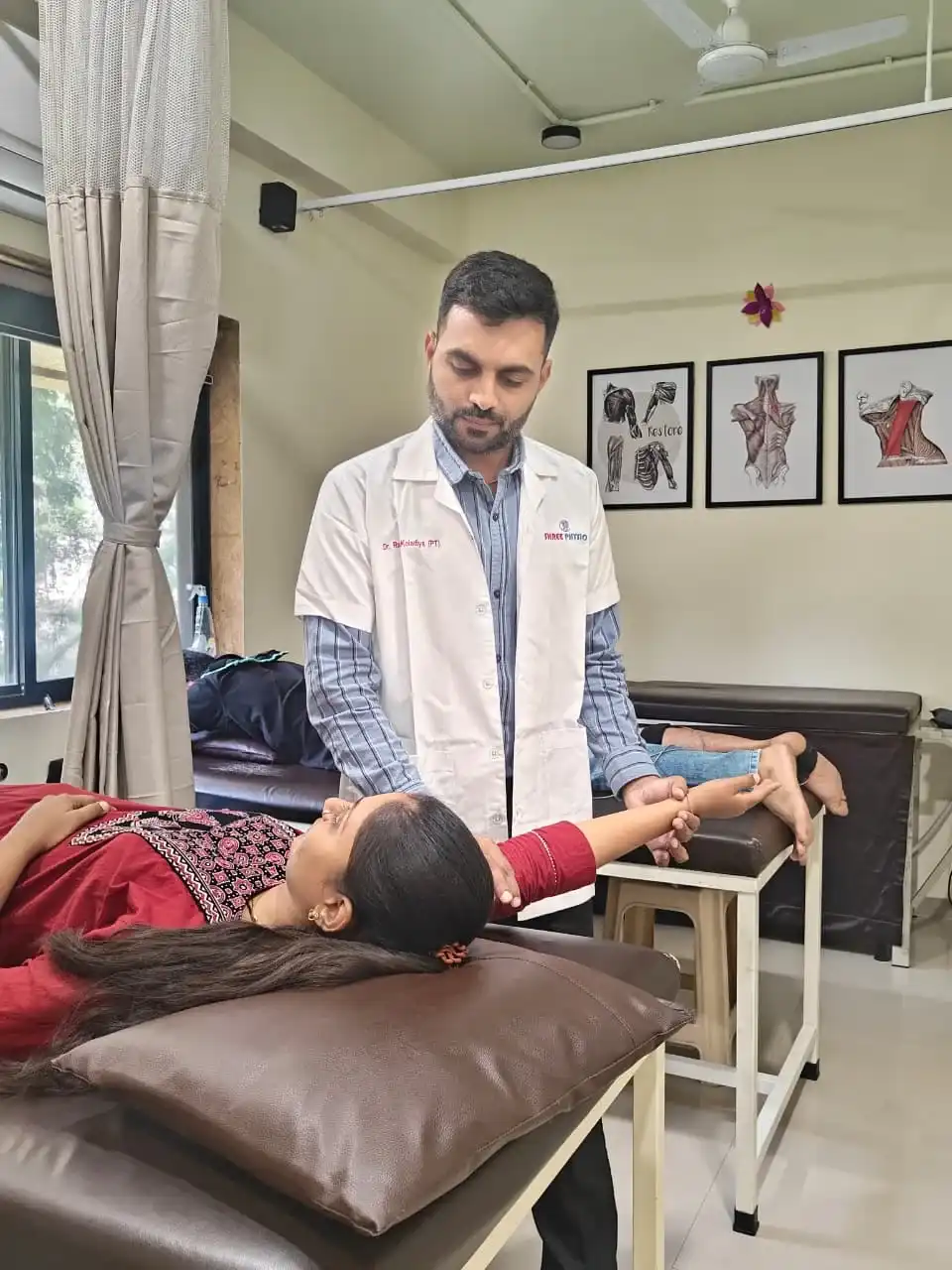 Integrative Manual Therapy session with a physiotherapist supporting a patient's head and arm during manual assessment.